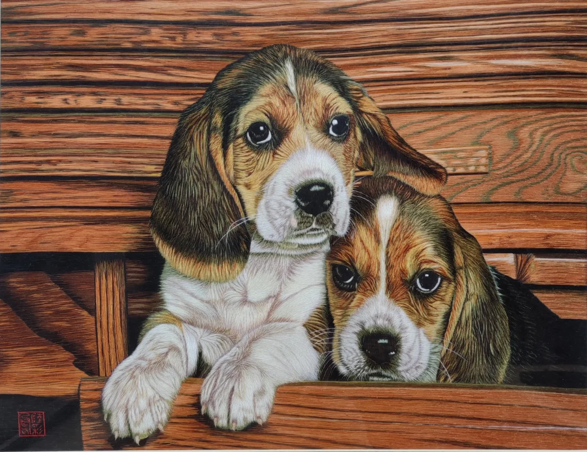 Two puppies hand-embroidered in fine silk for a Suzhou Threads portrait.
